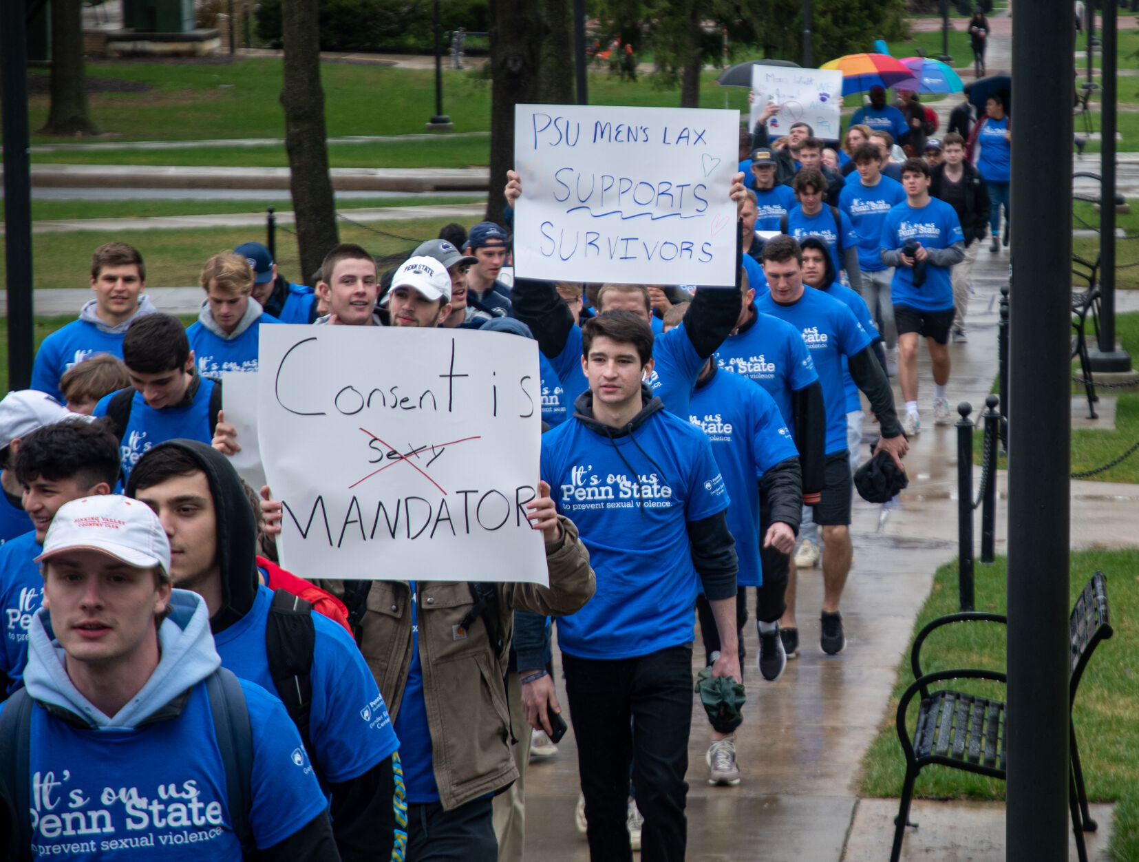 Handmade signs are held during Men Against Violence Walk